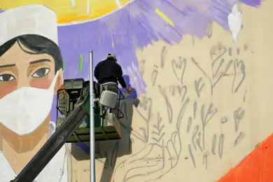 Столичные художники рисуют мурал, посвященный врачам