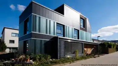 Облицовка стеклом и темными панелями придает дому современный облик